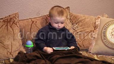 <strong>小男孩</strong>坐在沙发上看着智能手机上的<strong>卡通</strong>